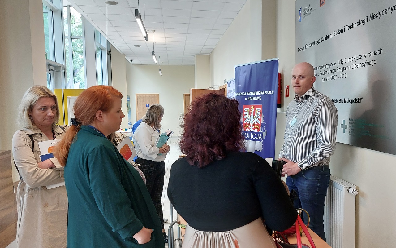 Małopolska Giełda Programów Profilaktycznych - uczestniczki konferencji oglądają materiały edukacyjne na stanowisku wystawienniczym Komendy Wojewódzkiej Policji w Krakowie 